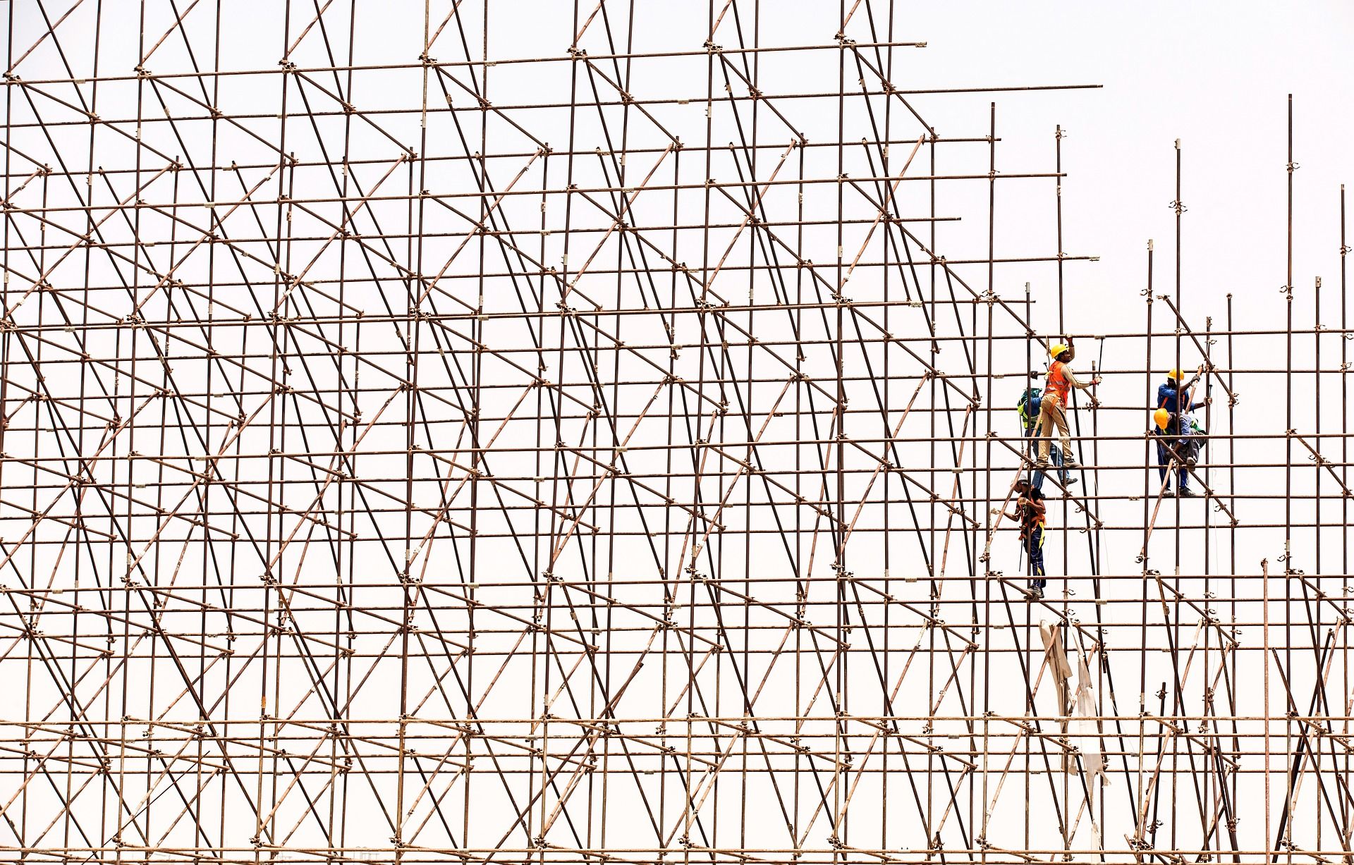 A photo of 4 construction workers working on scaffolding. 