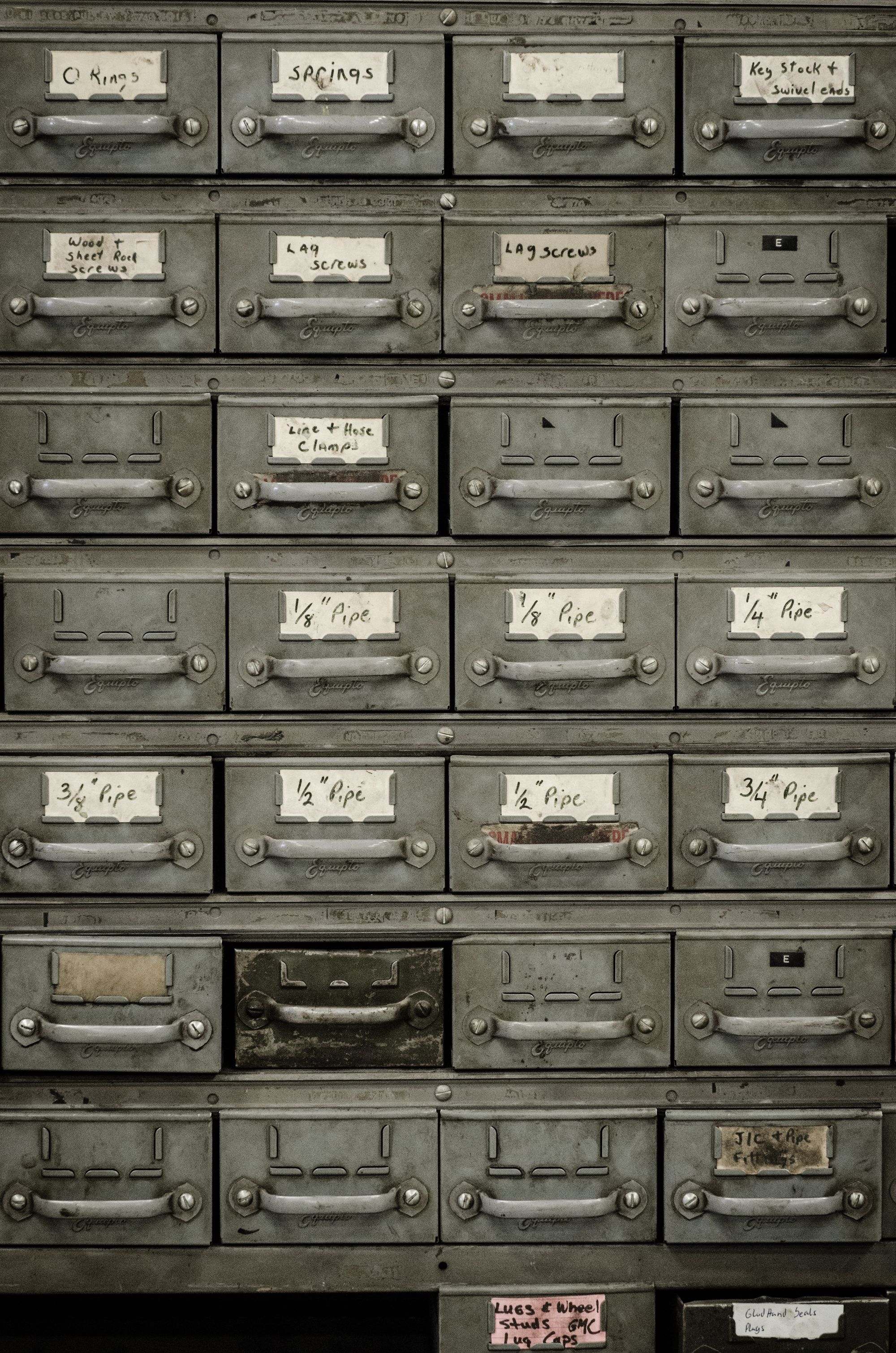 Rows and Columns of metal document cabinets with handwritten labels.