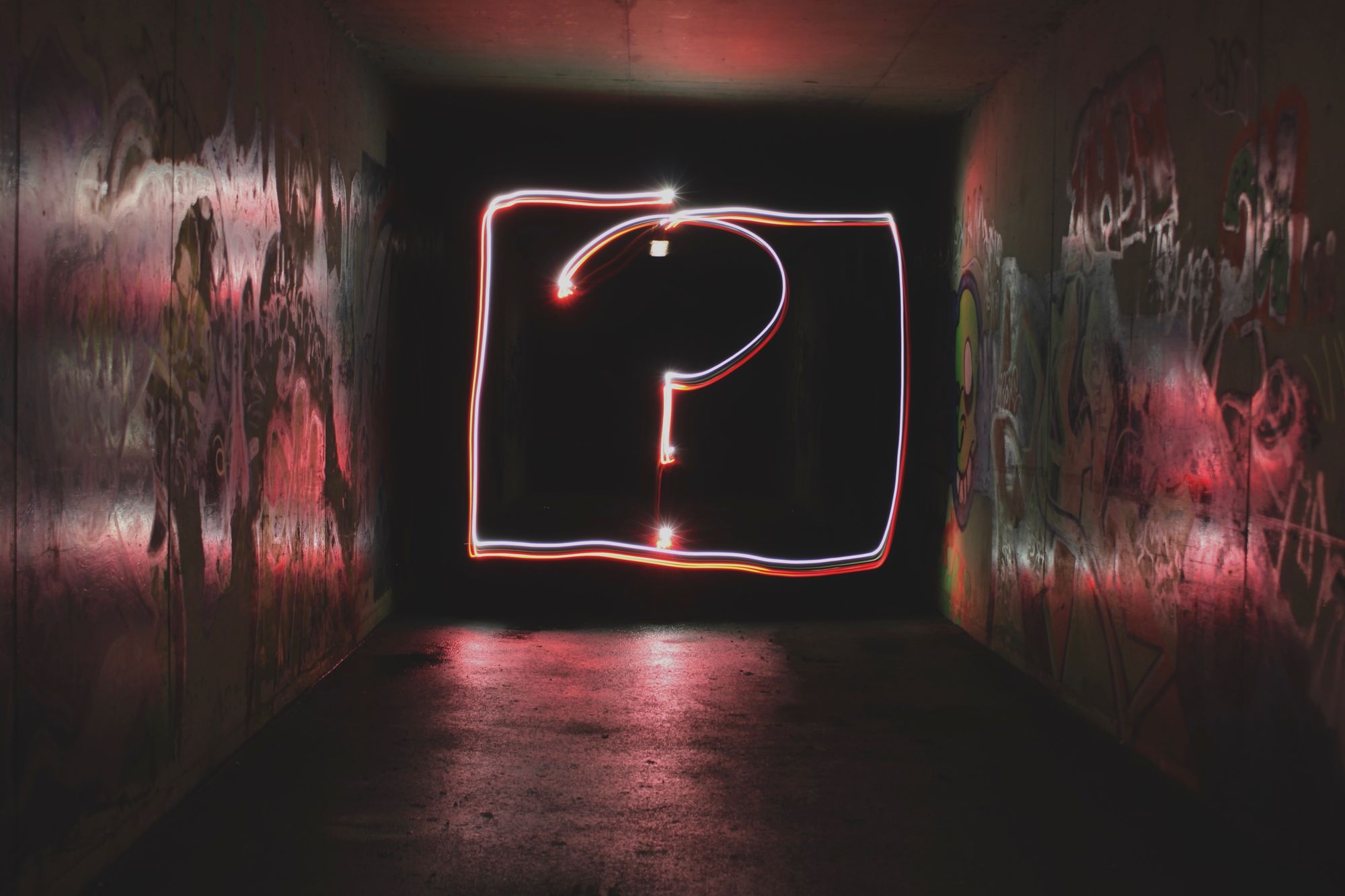 long exposure photograph where the light "drew" a question mark in a rectangle, in a tunnel