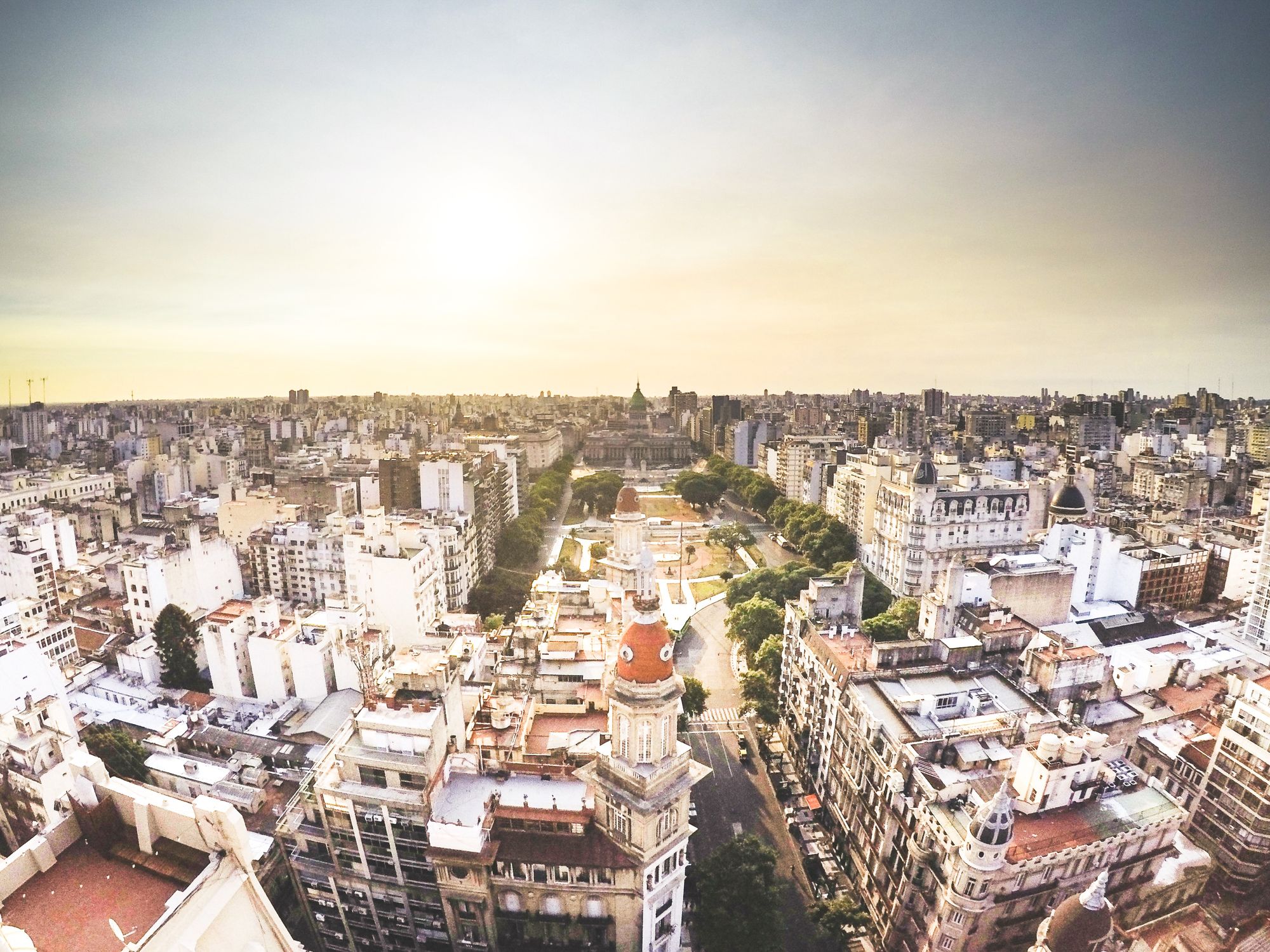 Aerial view of Buenos Aires cityscape against a yellow/white/grey sky.