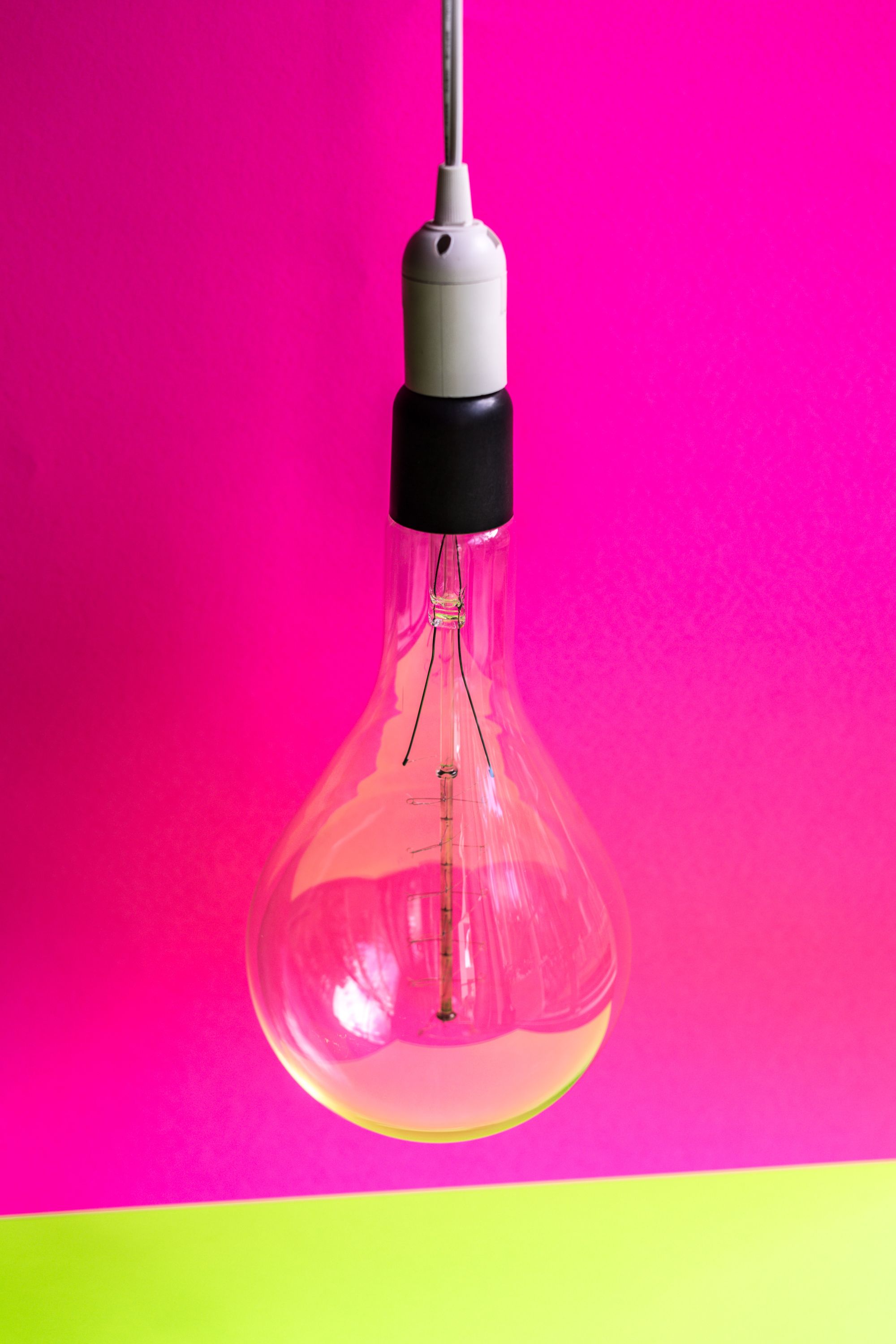 hanging light bulb on a pink and neon yellow background